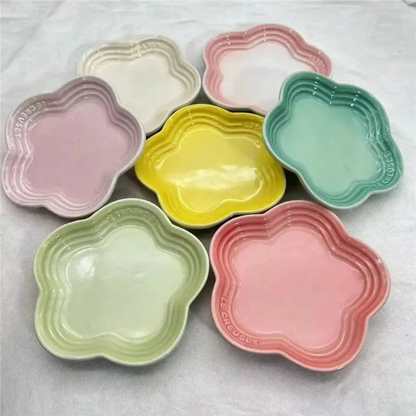 Pastel flower-shaped ceramic pet bowls in pink, yellow, green, and white for dogs or cats