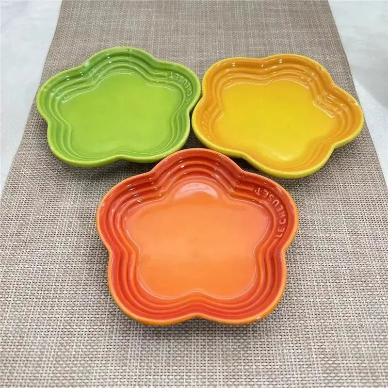 Colorful pet food bowls in green, yellow, and orange, ideal for dogs and cats, displayed on textured mat.